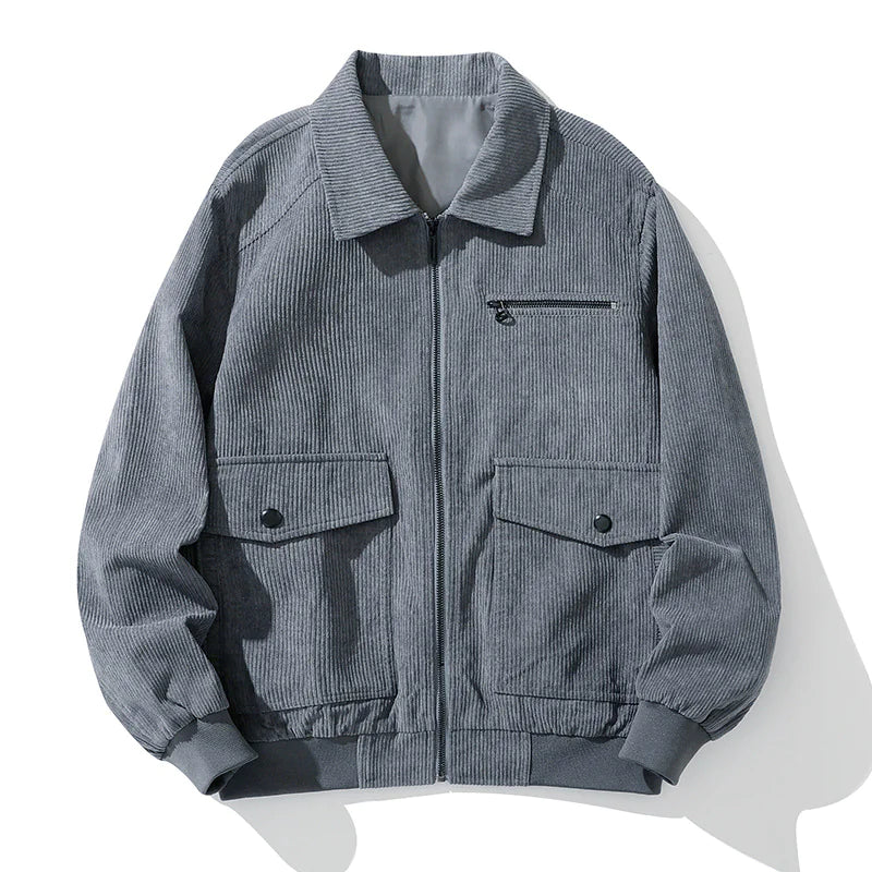 A vintage-style dark green corduroy jacket with a zip-up front, laid flat against a white background. The jacket features a classic collar, ribbed cuffs and hem, a zippered chest pocket, and two large flap pockets with button closures. The textured fabric gives it a stylish, retro-inspired look.