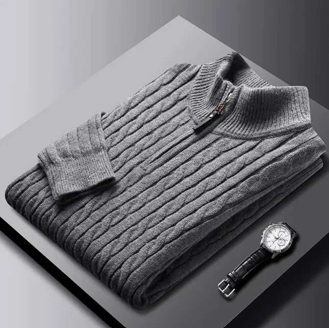 A neatly fold sweat shirt on a black surface with a black leather watch b the side