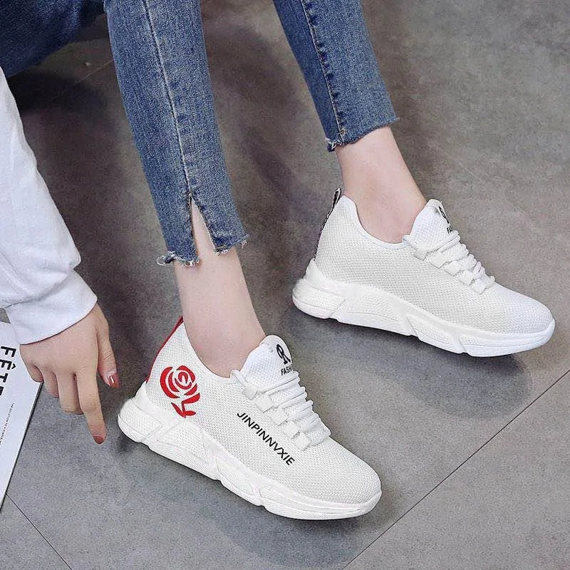 A pair of stylish mesh sneakers worn with jeans. The shoes feature colorful embroidered details The sneakers have a sleek, breathable design and a casual, trendy aesthetic.