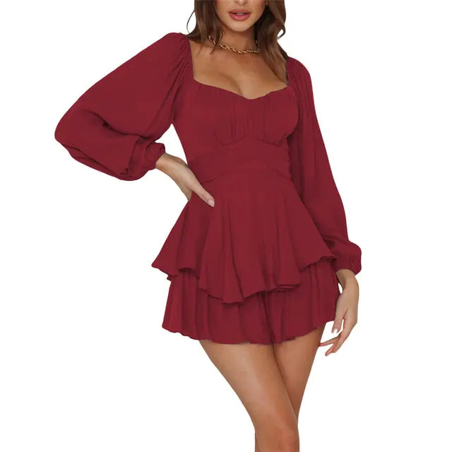 Woman wearing a stylish deep red long-sleeve mini dress with a sweetheart neckline, layered ruffle skirt, and puffed sleeves, posing with one hand on her waist