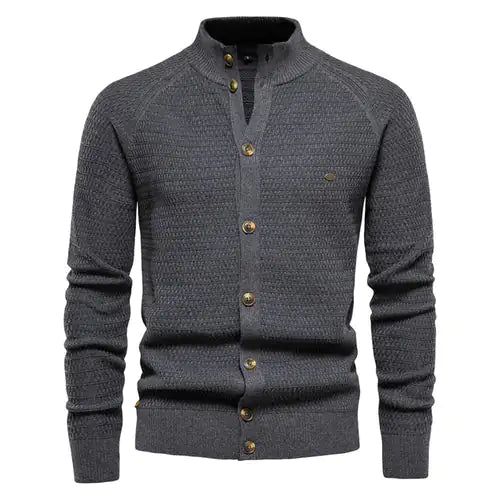 A sophisticated dark gray knitted cardigan with a mandarin collar and a button-up front. The cardigan features a textured pattern, ribbed cuffs and hem, and brown-toned buttons that add a stylish contrast. A small embroidered logo is visible on the left chest, enhancing its elegant design