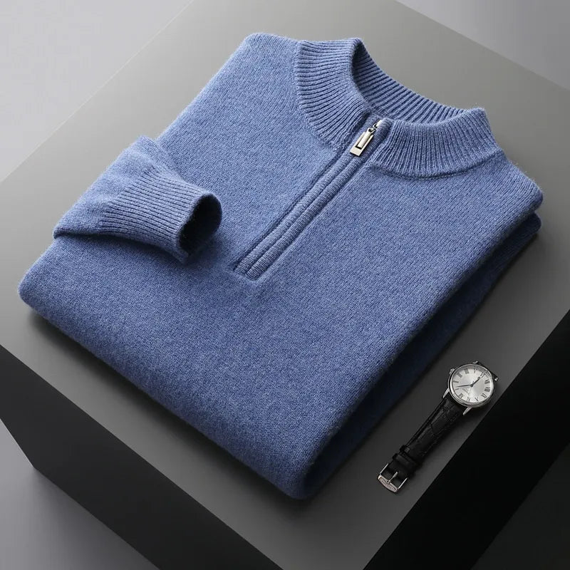 Folded sweat-shirt on a black box with a black leather watch beside it