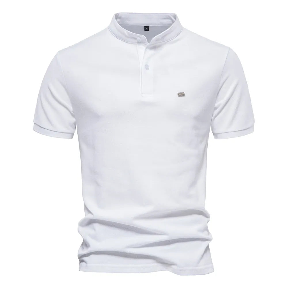 A beige short-sleeved polo shirt with a mandarin collar and a two-button placket. The fabric appears soft, and there is a small embroidered logo on the left chest. The shirt has a modern, slim fit with neatly stitched hems.