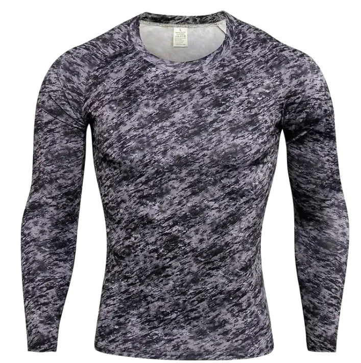 A long-sleeved athletic compression shirt with a gray, black, and white camouflage pattern on the front and sleeves. The shirt has black side panels and raglan-style sleeves, giving it a sporty and fitted design. The fabric appears to be stretchy and moisture-wicking, suitable for workouts or outdoor activities.