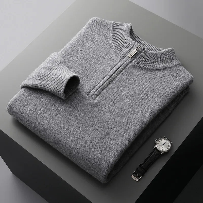 Folded sweat-shirt on a black box with a black leather watch beside it