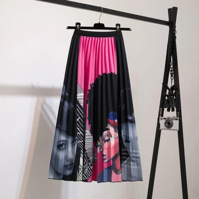 Pleated midi skirt with a gradient design, transitioning from dark black at the waistband to a soft blush pink at the hem, hanging on a black clothing rack next to a vintage-style camera.