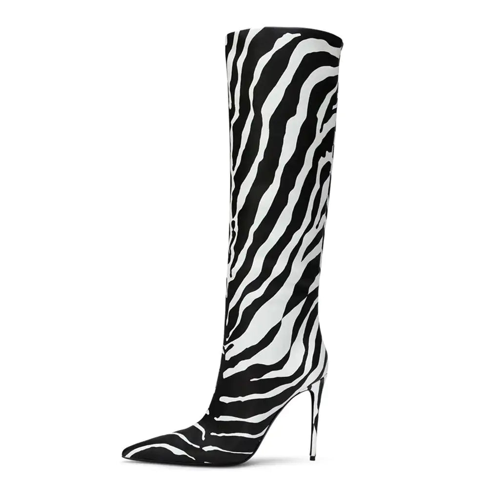 A single high-fashion women's knee-high boot in beige with a faux crocodile skin texture. The boot features a pointed toe and a slender stiletto heel, exuding a luxurious and stylish appearance. It is photographed against a plain white background, showcasing its elegant structure and upscale finish.