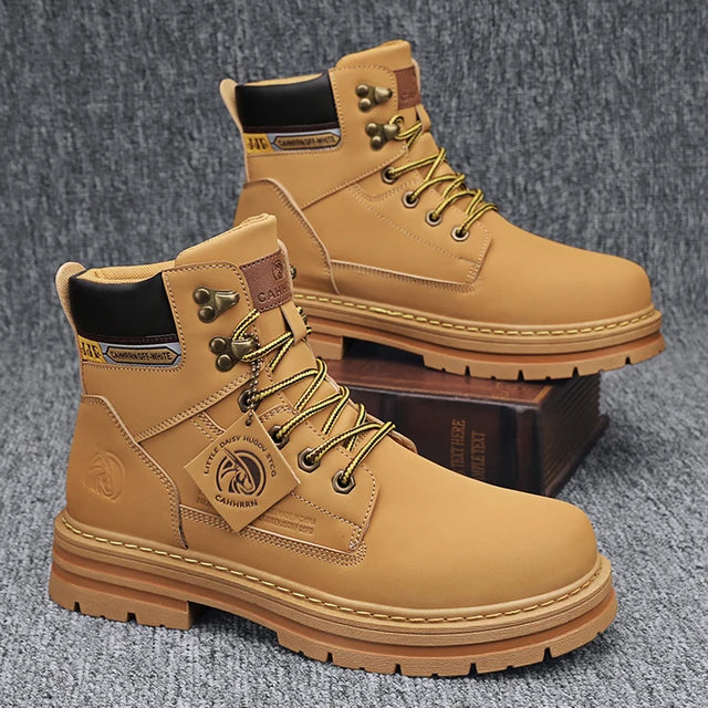 A pair of tan high-top boots with a thick jute-wrapped sole and colorful teddy bear patchwork fabric on the sides. The boots have a rugged design with metal eyelets and a branded patch on the side, displayed against a warm brown background.