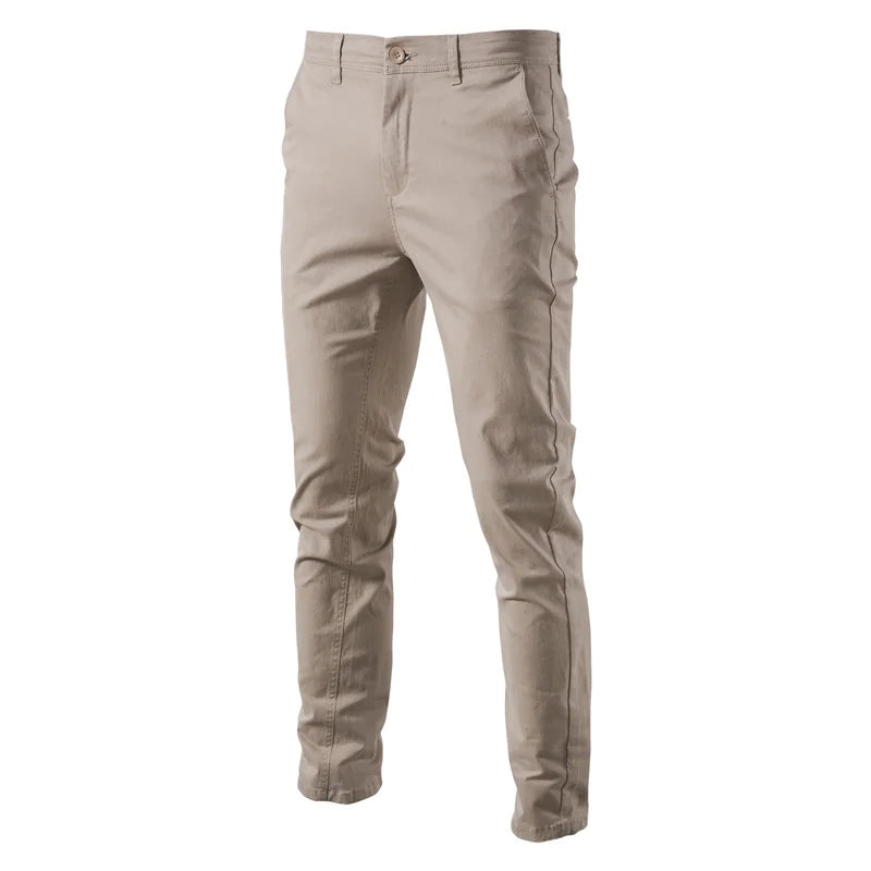 A pair of slim-fit navy blue men's trousers made from a smooth fabric. The pants feature a button and zipper closure, belt loops, and side pockets. The tailored design gives them a sleek and modern look, suitable for both casual and semi-formal occasions.