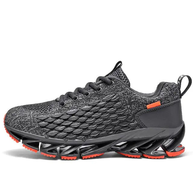 A black and dark gray athletic sneaker with a breathable knit upper, accented by bold orange wave-like stripes on the sides and orange detailing on the midsole. The shoe features a thick, textured sole and black-and-white patterned laces, designed for both style and performance.