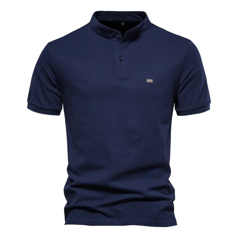 A beige short-sleeved polo shirt with a mandarin collar and a two-button placket. The fabric appears soft, and there is a small embroidered logo on the left chest. The shirt has a modern, slim fit with neatly stitched hems.