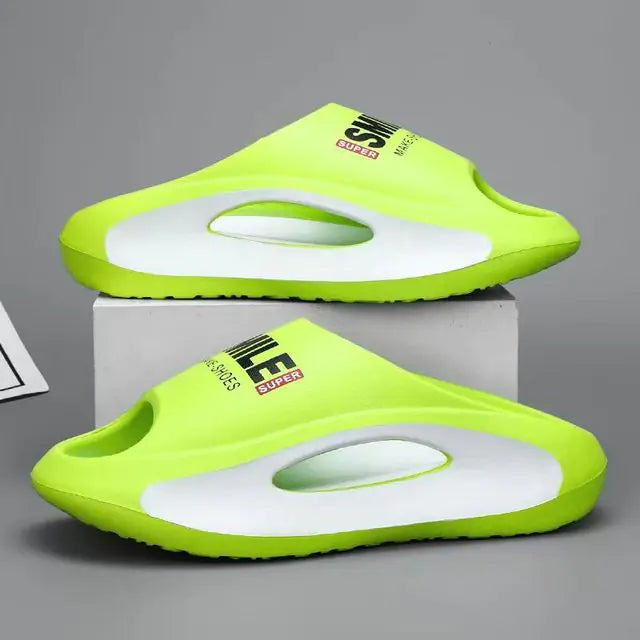 A pair of stylish black slip-on sandals with purple cushioned insoles, featuring cutout designs on the sides and toes, displayed on a white surface next to stacked books.