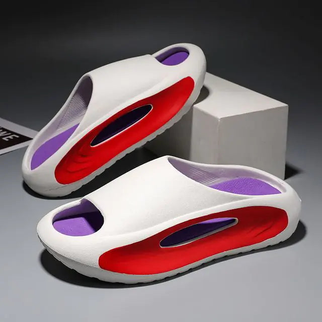 A pair of stylish black slip-on sandals with purple cushioned insoles, featuring cutout designs on the sides and toes, displayed on a white surface next to stacked books.