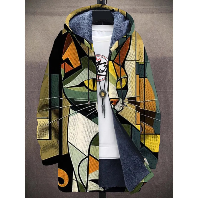 A trendy hooded jacket with a bold, abstract cat face design in a geometric style. The jacket features a mix of green, yellow, black, and beige tones, with a fleece-lined interior, a front zipper, and adjustable drawstrings on the hood. It is layered over a white T-shirt with a circular graphic print and accessorized with a long pendant necklace.