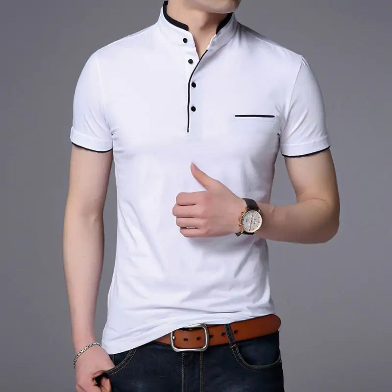 A stylish short-sleeved polo shirt with a mandarin collar, white trim detailing, and a partial button-up design. The shirt features a small decorative white-lined pocket on the left chest. The model is wearing dark jeans, a brown leather belt, a wristwatch, and a bracelet, posing casually with one hand resting on the belt buckle