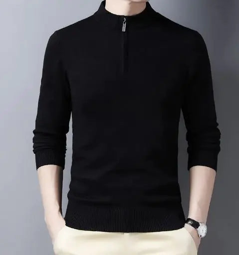 A stylish black slim-fit sweater with a quarter-zip collar, worn by a male model against a neutral gray background. The sweater has a ribbed hem and cuffs, giving it a sleek and fitted appearance. The model is also wearing light-colored trousers and a silver wristwatch, adding a touch of sophistication to the outfit.