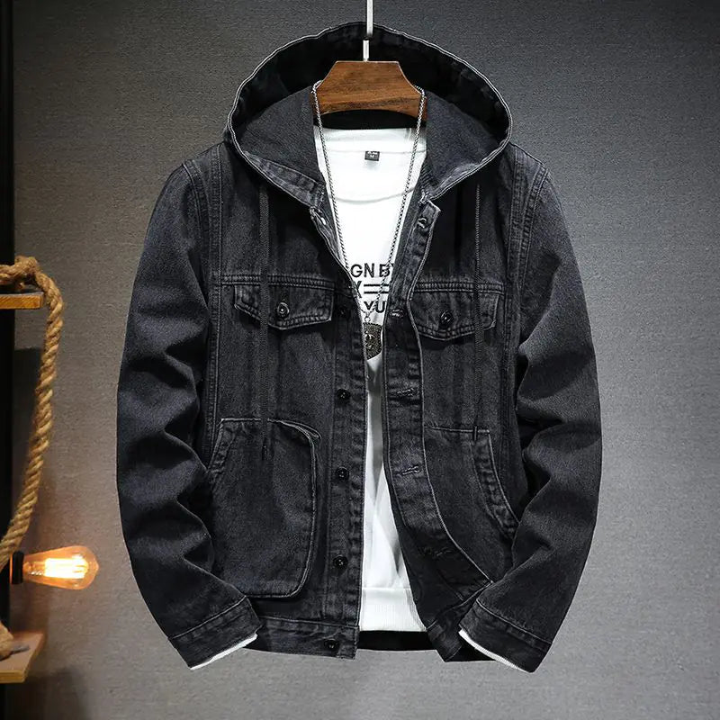 A stylish black denim jacket with a hood, layered over a white graphic t-shirt and accessorized with a silver pendant necklace. The jacket features a button-up front, multiple pockets, and a slightly distressed finish, giving it a rugged yet fashionable look. The hoodie detail adds a modern, casual touch, making it perfect for streetwear or casual outings.