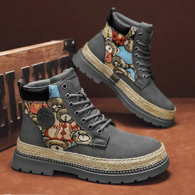 A pair of tan high-top boots with a thick jute-wrapped sole and colorful teddy bear patchwork fabric on the sides. The boots have a rugged design with metal eyelets and a branded patch on the side, displayed against a warm brown background.