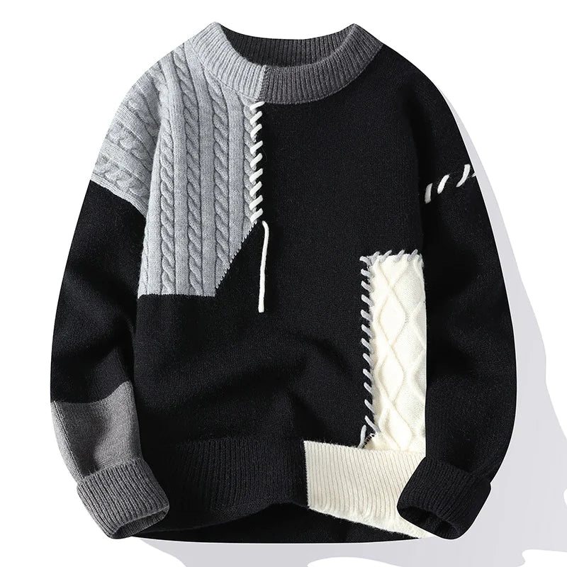 A patchwork-style sweater with a black base, featuring contrasting gray and off-white ribbed knit textures. The design includes cable knit sections in gray and white, decorative stitching details, and ribbed cuffs, collar, and hem, creating a bold and modern aesthetic.