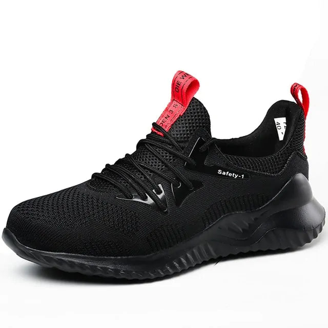 A black and dark gray athletic sneaker with a breathable knit upper, accented by bold orange wave-like stripes on the sides and orange detailing on the midsole. The shoe features a thick, textured sole and black-and-white patterned laces, designed for both style and performance.