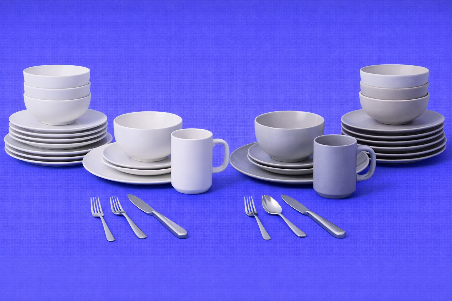 Dinnerware set with bowls, cups, plates, and cutlery on a blue background