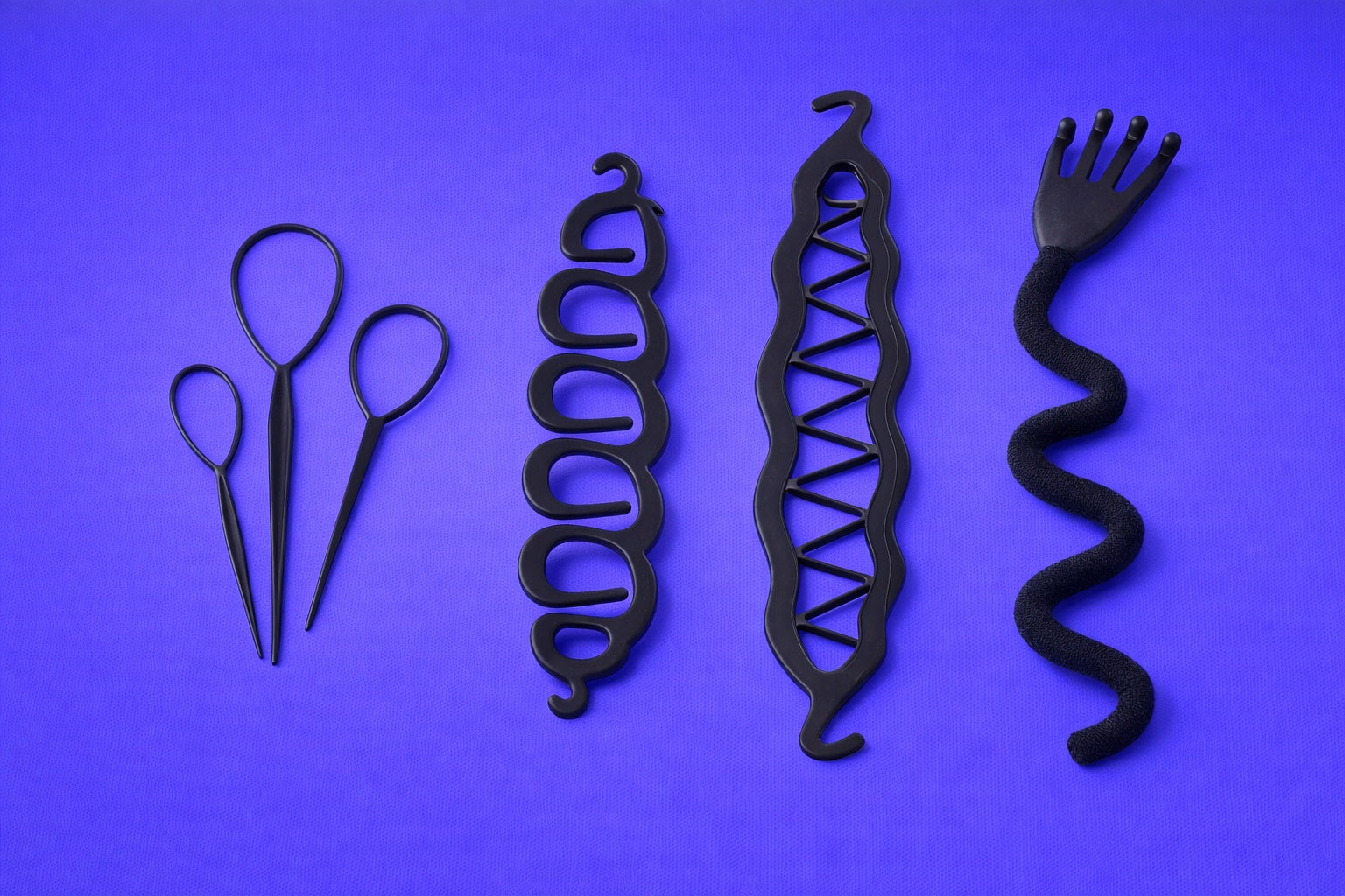 Black metal hair styling tools on a purple background