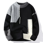A patchwork-style sweater with a black base, featuring contrasting gray and off-white ribbed knit textures. The design includes cable knit sections in gray and white, decorative stitching details, and ribbed cuffs, collar, and hem, creating a bold and modern aesthetic.