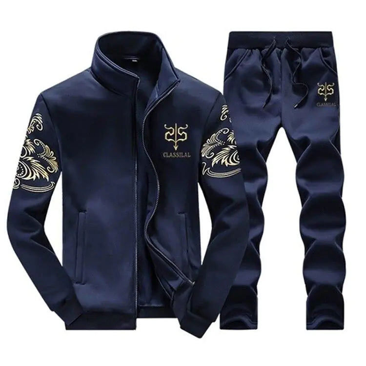 Navy blue men’s tracksuit set with a zip-up stand-collar jacket and matching jogger pants, featuring gold crest-style logos and ornate gold sleeve patterns.
