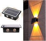 Solar-powered wall light with dual LED bulbs, shown from two angles: one side view with dimensions and another with the light installed on a wall, emitting yellow light.