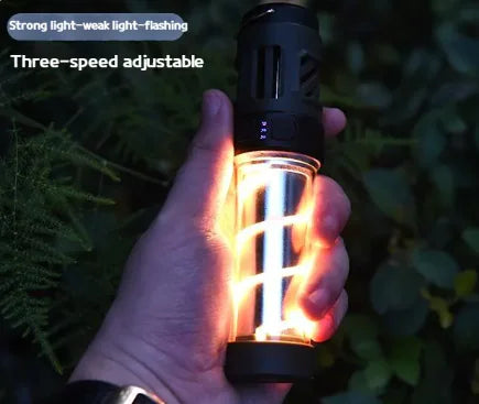 Hand holding a glowing portable outdoor lantern/flashlight at night, with text reading “Strong light–weak light–flashing” and “Three-speed adjustable