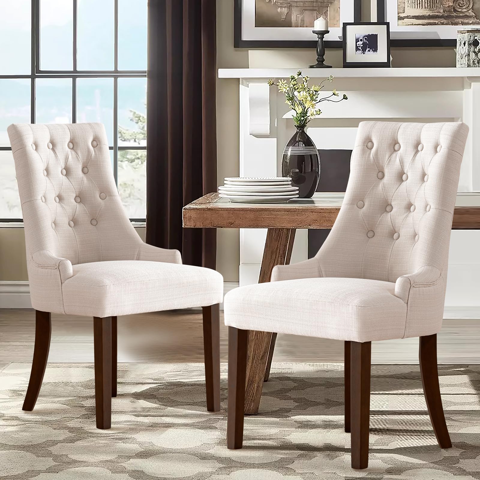 Two white upholstered chairs with wooden legs in a dining room setting.