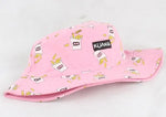 Pink wide-brim bucket hat printed with cartoon fries and small labels, including a black patch reading “KUANG,” on a white background.