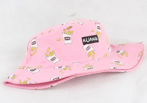 Pink wide-brim bucket hat printed with cartoon fries and small labels, including a black patch reading “KUANG,” on a white background.