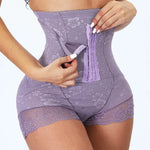 Model wearing a high-waisted purple floral lace shapewear shorts with a front hook-and-eye closure panel being adjusted by hand.