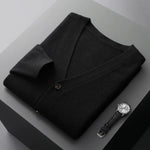 A neatly fold shirt on a black  surface with a black leather wrist-watch beside it