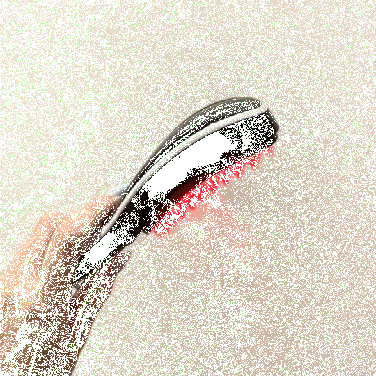 This image shows a handheld electric hair/scalp brush (a massaging/therapy brush):

A person is holding a curved, ergonomic brush.

The underside has soft silicone bristles (the pink/red nubs), designed to massage the scalp and help distribute shampoo or treatment oils.

The top looks like a smooth plastic housing, consistent with electric vibration/heat/light therapy style scalp brushes.

The green speckled pattern across the image appears to be digital noise/compression artifacts or an overlay, not part o