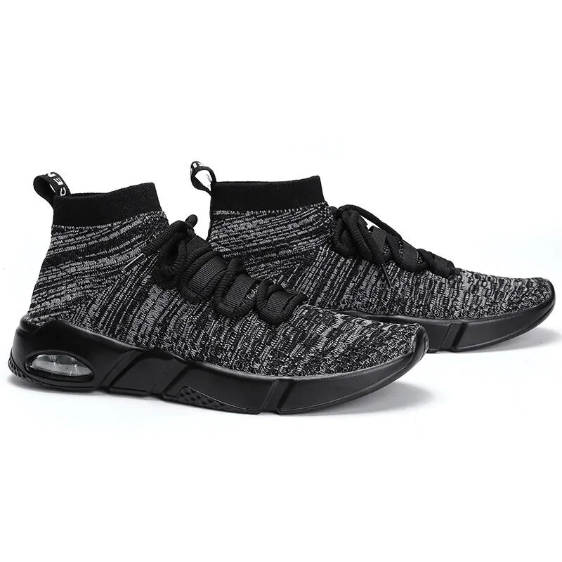 A pair of gray-and-black knit high-top sneakers with black laces, sock-like collars, and chunky black soles with a small visible air cushion, shown on a white background.