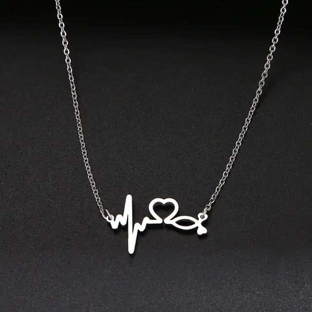 A delicate gold chain necklace featuring a tilted, hollow heart-shaped pendant. The heart is asymmetrically attached at both top curves to the chain, giving it a stylish slant. The background is plain white, highlighting the necklace's elegant and minimalist design.