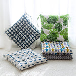 Four patterned cushions on a white surface with a light background