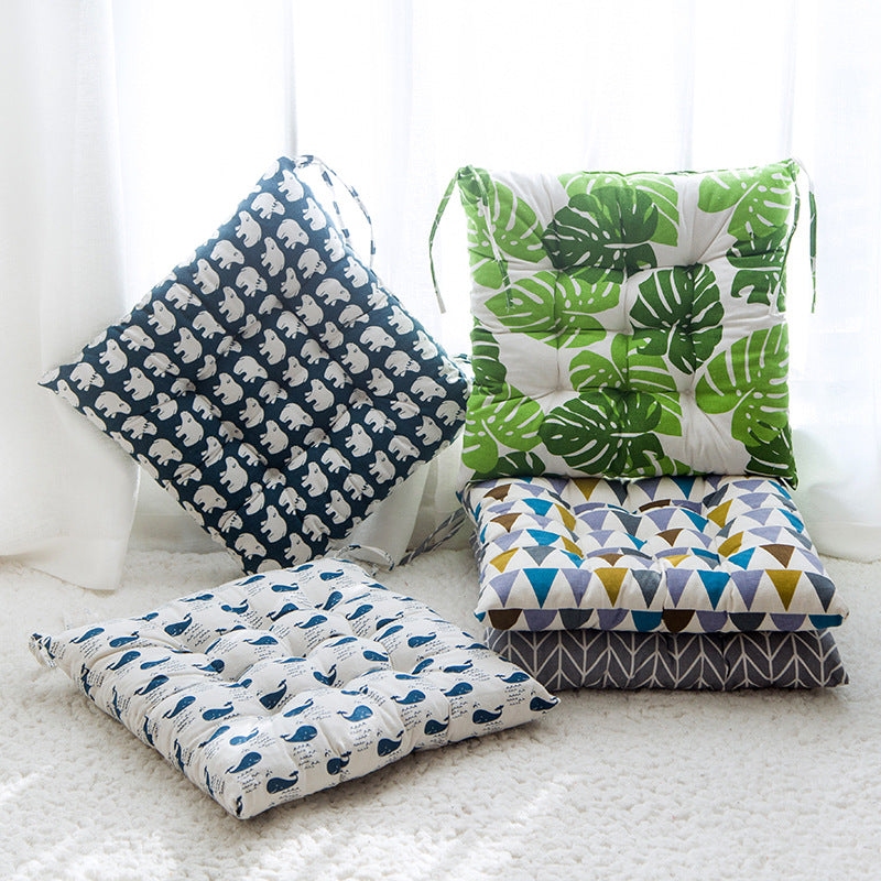 Four patterned cushions on a white surface with a light background
