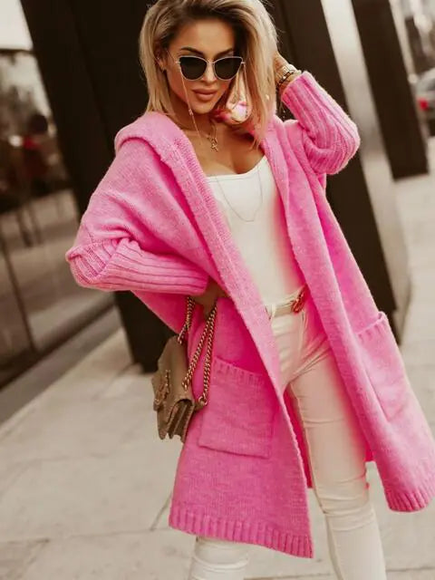 Woman wearing a bright pink coat with a blurred background