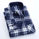 A neatly folded men's flannel shirt featuring a navy blue and white plaid pattern. The shirt has a structured button-down collar, black buttons, and a single chest pocket. The fabric appears soft and warm, making it ideal for casual and outdoor wear. The contrasting white and dark blue checks add a stylish yet classic look, suitable for various occasions.