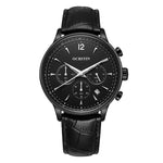 Black analog chronograph wristwatch with a textured black dial, three subdials, large white Arabic numerals, a date window, and a black leather strap, shown on a white background.
