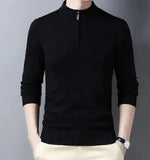A stylish black slim-fit sweater with a quarter-zip collar, worn by a male model against a neutral gray background. The sweater has a ribbed hem and cuffs, giving it a sleek and fitted appearance. The model is also wearing light-colored trousers and a silver wristwatch, adding a touch of sophistication to the outfit.