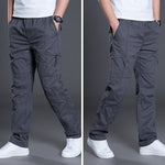 Person wearing gray cargo pants with multiple pockets on a gray background
