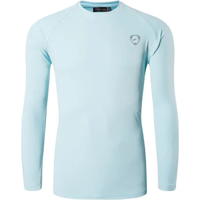 A sleek, light gray long-sleeve compression shirt with a crew neck, featuring a small logo on the upper left chest. The fabric appears smooth and stretchy, designed for athletic or casual wear.