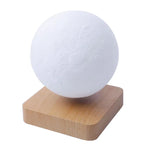 White spherical moon lamp with a cratered texture, sitting on a small square wooden base.