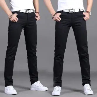 A pair of slim-fit burgundy pants is showcased by a model in two poses against a neutral gray background. The pants are paired with a white belt featuring a bold black buckle design, a white tucked-in shirt, and white sneakers. The model wears a wristwatch and bracelets, adding a stylish touch. The pants have a sleek, modern fit, emphasizing a trendy and casual yet polished look.