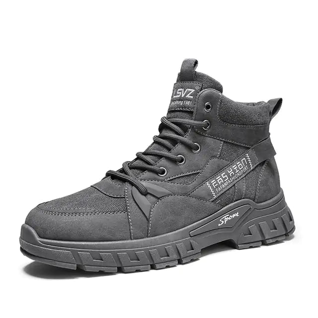 A rugged dark gray high-top sneaker boot with thick treaded sole, lace-up front, mesh and synthetic panels, and white printed text details on the side and tongue, displayed against a plain white background.