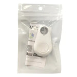 A small white key-finder tracker with a round button and LED sits inside a clear resealable pouch, with a folded instruction card behind it.